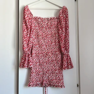 Klänning - Fin klänning med röda blommor på. Storlek 8 (passar dig som har storlek S)
