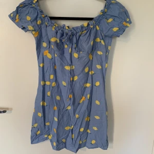 Ny klänning - Otroligt fin klänning med citroner på, helt ny, går till mitten av låren, i storlek M, skulle säga att den är lite liten i storlek 