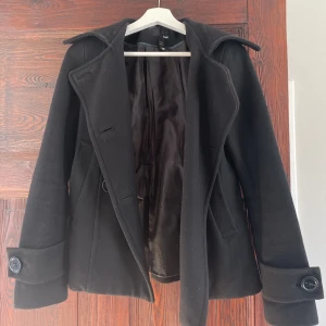 Svart kort kappa - En svart kort kappa som är sååå trendig nu i vår. Den är köpt second hand men är knappt använd av mig så den är i bra skick :) 