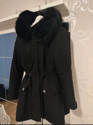 Parkas med fin luva - Svart parkas med fin stor luva Finns päls inuti som gör den gosig och varm till vintern.