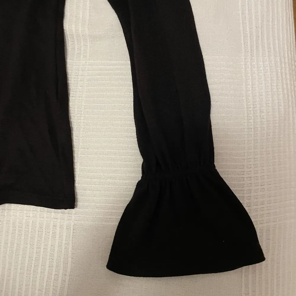 Tunnstickad svart blus/tröja med detalj i ärmslut. Storlek XS i gott skick.. Tröjor & Koftor.
