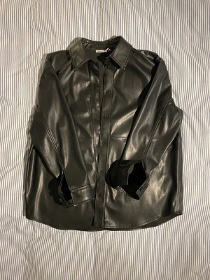 Svart Weekday Shirt Faux Leather - Bra skick, inga tecken på slitage, bara använd några gånger.
