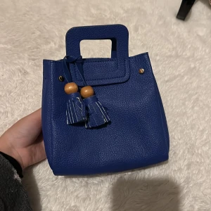 Blå liten väska - Blå väska med en fin detalj och tillhörande band