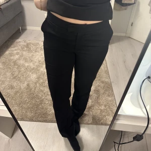 Kostymbyxor  - Säljer ett par kostymbyxor från Nakd. Använda ett fåtal gånger. Lågmidjade och raka ben. Jag på bilden är 170cm lång.