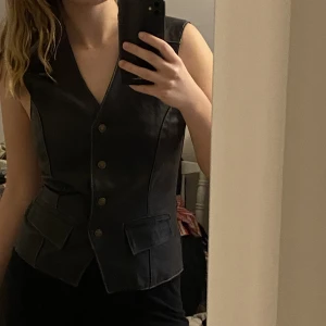 Läderväst  - Vintage svart äkta läder väst från Courtney of London. Knyts bak som en korsett för önskad passform. Inga defekter. 