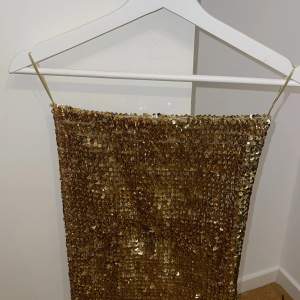 Kjol med guldpaljetter i storlek S, kan även användas som topp 