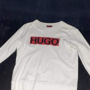 En jätte fin vit Hugo sweatshirt. Tröjan är använd ett par gånger, men fortfarande i fantastiskt skick.  Det finns bara ett litet hål vid ärmen, men den syns knappt. Storlek Xs men stor i storlek. Originalpris: 1069kr 