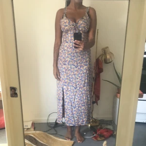 Klänning  - En långklänning med slits och välansade axelband och urringning. Använd fåtal gånger.