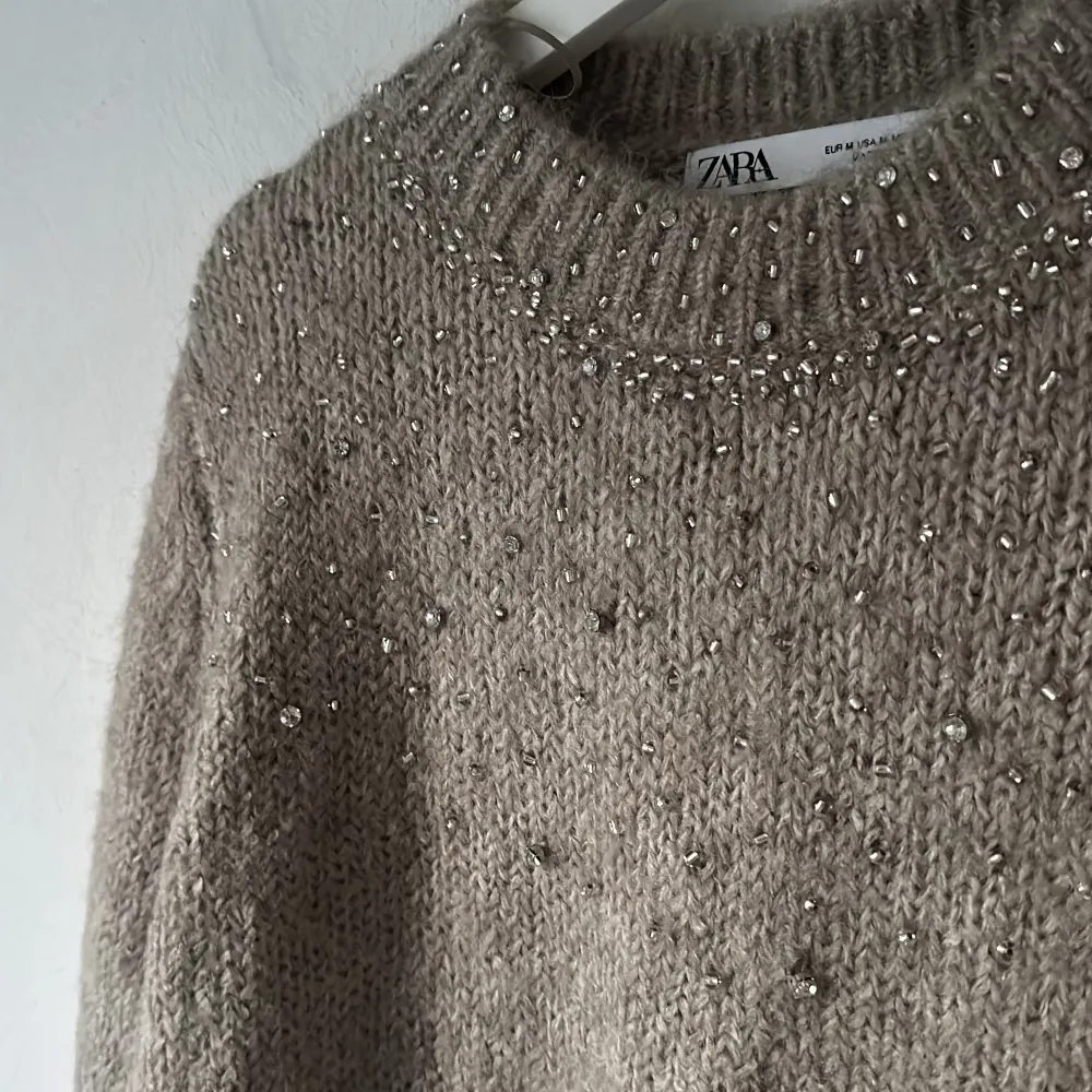 Nyligen inköpt stickad tröja med pärlor från Zara. Är brun/begie i färgen och i storlek M. Använd en gång!. Stickat.