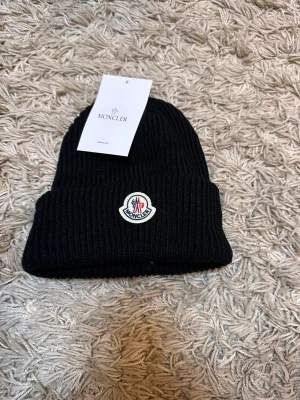 Moncler  mössa - Hej, säljer denna nya mössan som är i ny skick och aldrig använt