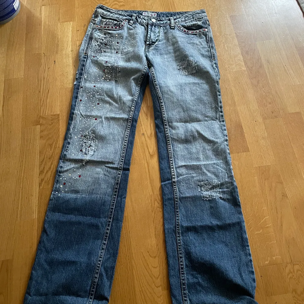 Helt fantastiska lågmidjade bootcut jeans me snygga rhinestone detaljer å slitningar. I nyskick!! Jag är 165 cm för referens. Mått: 40 cm midja tvärs över, 87 cm innerbenslängd . Jeans & Byxor.