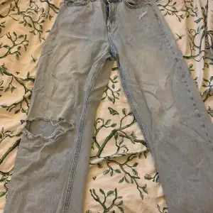 Ett par baggy jeans från H&M med hål i knät. Är storlek 38 men skulle säga att den mer är 36