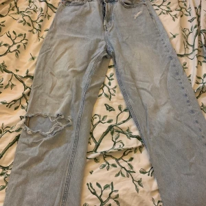 Baggy jeans  - Ett par baggy jeans från H&M med hål i knät. Är storlek 38 men skulle säga att den mer är 36