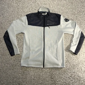 Peak Performace fleecejacka  - En blå och grå fleecejacka från Peak Performance. Perfekt för höstkvällen. Storleken är L men den är liten i storleken. Utöver texten på framsidan så är den i gott skick. 