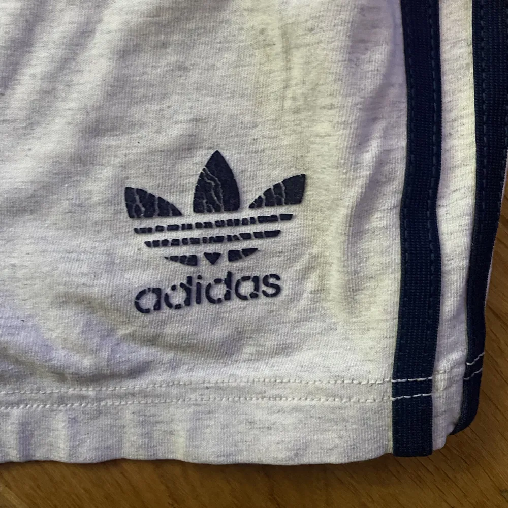 Gråa adidas cykelbyxor med blåa ränder. Sitter tight. Använda många gånger men ändå fina. Skriv för bild på 🤍. Shorts.