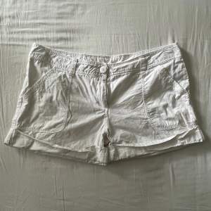 Supersöta vita lågmidjade shorts. Begagnat skick, men inga fläckar eller hål! Midjemått mätt rakt över: 46cm, längd: 31cm. Storlek 42🫶💕
