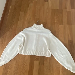 Vit stickad tröja  - Vit långärmad stickad tjöja med dragkedja. I fint skick inga fläckar, väl omhändertagen 