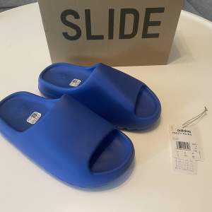 Hej! Säljer ett par DEADSTOCK Yeezy Slides Azure. Strl 43. Köpta på Adidas CONFIRMED. Kvittot och originalbox medföljer. 