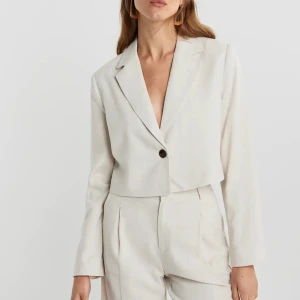 Cropped linen blazer - Kort kavaj från Gina tricot. Använd 1 gång och i superfint skick. Har en liten fläck (se bild 2) som inte syns när man använder.