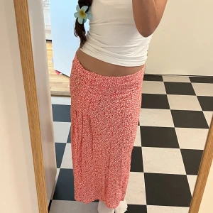 Snygg röd långkjol - Snygg röd långkjol med vita detaljer💋⭐️luftigt material och dold dragkedja i sidan. Nypris 200 kr. Inga defekter♥️ 36 cm tvärs över midjan och 76 cm runt om