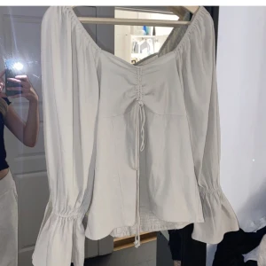 Blus med prislapp kvar  - Aldrig använd med prislapp kvar. Köpt för ca 2 år sedan, har aldrig kommit till användning men är superfin. Färgen är typ som en blandning mellan bilderna med och utan blixt, kan ta fler bilder vid intresse. Storlek m men passar mer en s 