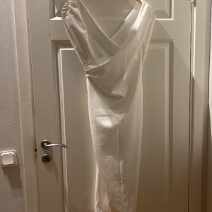 Vit student/skolavslutning klänning  - SJUKT fin klänning till studenten/skolavslutning. Går att ha helt off shpulder eller bara lite boat neck. Tight formande modell och ger så fin definition av kroppen! Kvinnlig och elegant! Använd en gång på skolavslutning. 