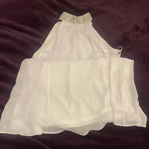 vit klänning utan armar - En vit klänning utan armar som stannar ungefär vid knäna. Passar perfekt till studenten. Oanvänd.