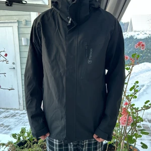 Tenson vinterjacka - Tenson vinterjacka med avtagbar huva, svart, i storlek M. Innersidan är avtagbar så det kan bli en skaljacka.