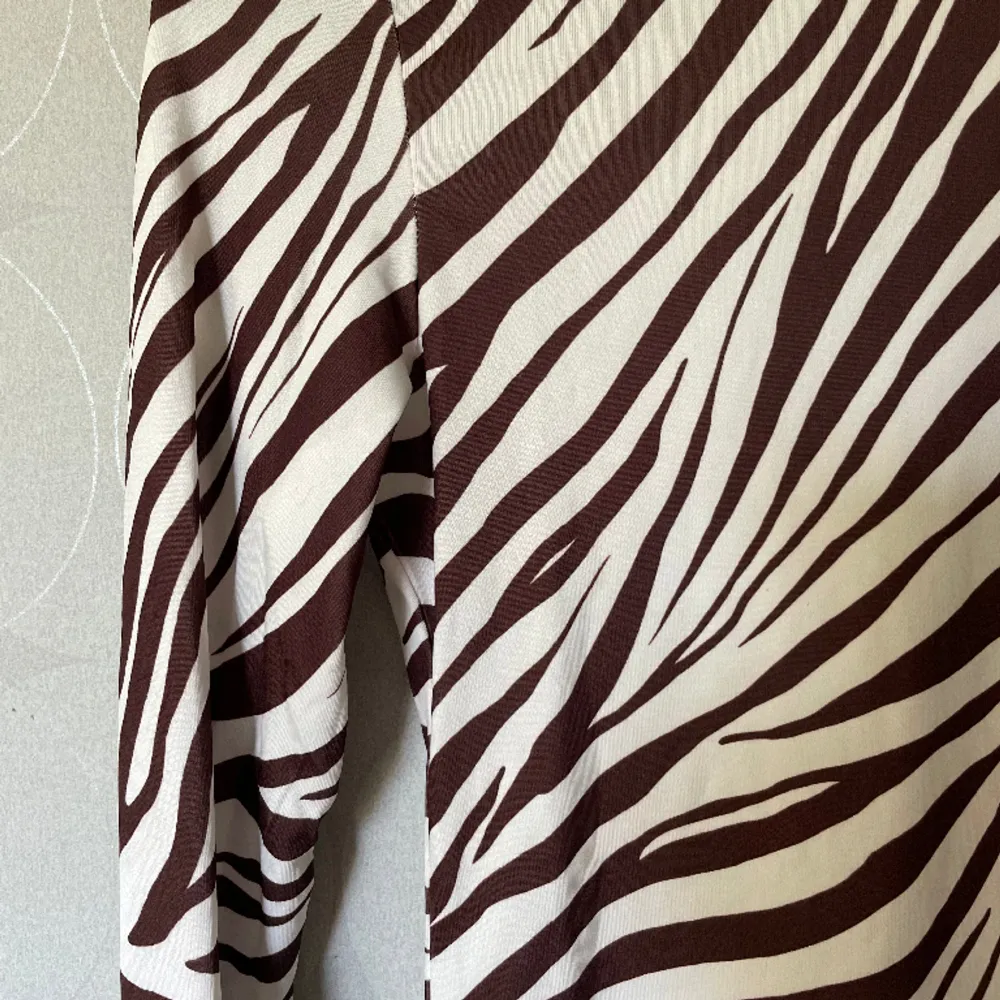 En tröja i zebramönster, färgerna brun och vit. Är väldigt skönt material, sitter tight. Fint skick!. Tröjor & Koftor.