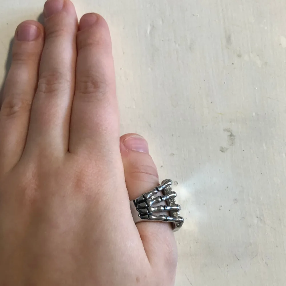 Silver ring, skelett hand som håller i ett spelkort. Stor ring som typ passar på min tumme. . Accessoarer.