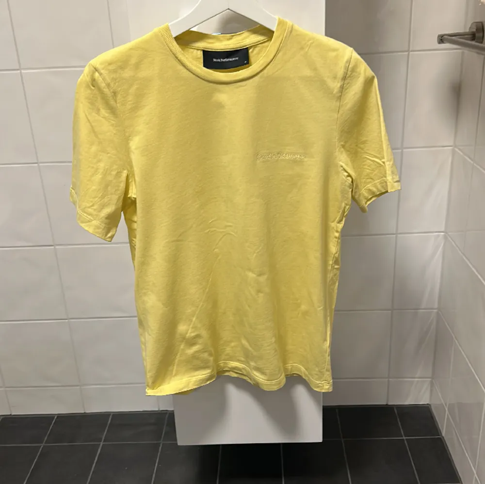 En fin t-shirt från peak performance i gul, oanvänd, storlek M. T-shirts.