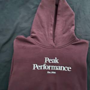 En helt ny brun Peak Performance hoodie i nyskick. Endast använd 1 gång.