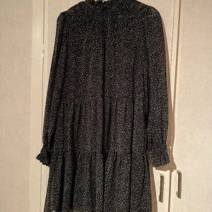 Klänning - Svart långärmad klänning med vita prickar.  Använd ett fåtal gånger 
