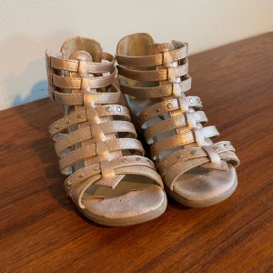 Sandaler guldfärgade i storlek 29 - Sandaler i bra begagnat skick från Din sko.  Guldfärgade i storlek 29.