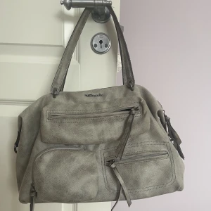 Tamaris väska  - Jätte fin väska från märket Tamaris som inte kommer till användning längre, man får plats med mycket då det finns många fickor. Finns lite defekter kan skicka bild om man frågar💗