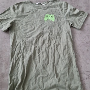 Tischa från HM - En ljusgrön tischa från HM, gamer edition, barnstorlek 158-164, 8 av 10.