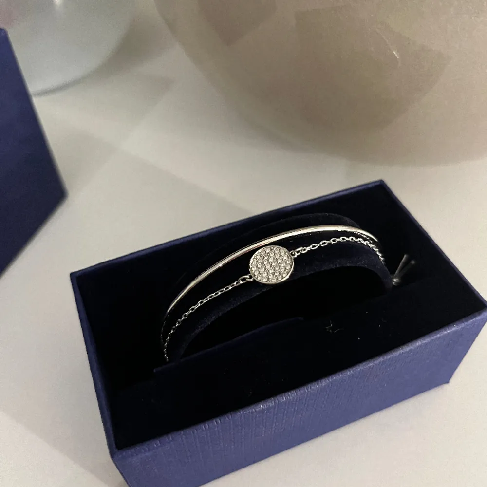 Säljer detta fina armband från Swarovski, aldrig använt!✨ Armbandet är i äkta silver och både delarna sitter ihop med varandra. Nypris 1,150kr Kontakta mig vid fler bilder/ frågor!. Accessoarer.