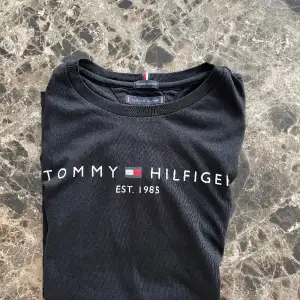 En svart T-shirt från Tommy Hilfiger i mycket gott skick. Bilden på denna annons blir dålig för någon anledning, originella bilden kan skickas via DM.