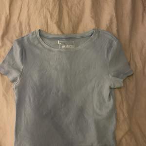 En blå T-shirt, lite kortare modell köpt från newyorker