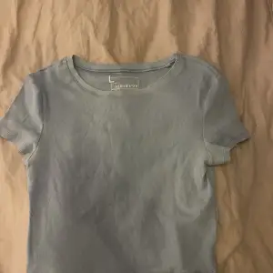 En blå T-shirt, lite kortare modell köpt från newyorker