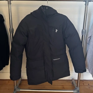 Peak performance Jacka - äkta Peak performance jacka. Har växt ur jackan så den kommer inte till användning.  Jackan är i bra skick och det ända som är en ” skada ” är den saken innanför vid luvan, ni ser på tredje bilden men det är ingenting som stör. 