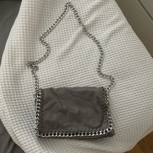 Väska - Grå väska med silverfärgad kedja från Tiamo