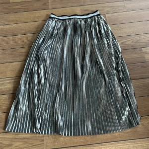 Kjol - Plisserad kjol. Lite sliten i resån, men det syns knappt. 