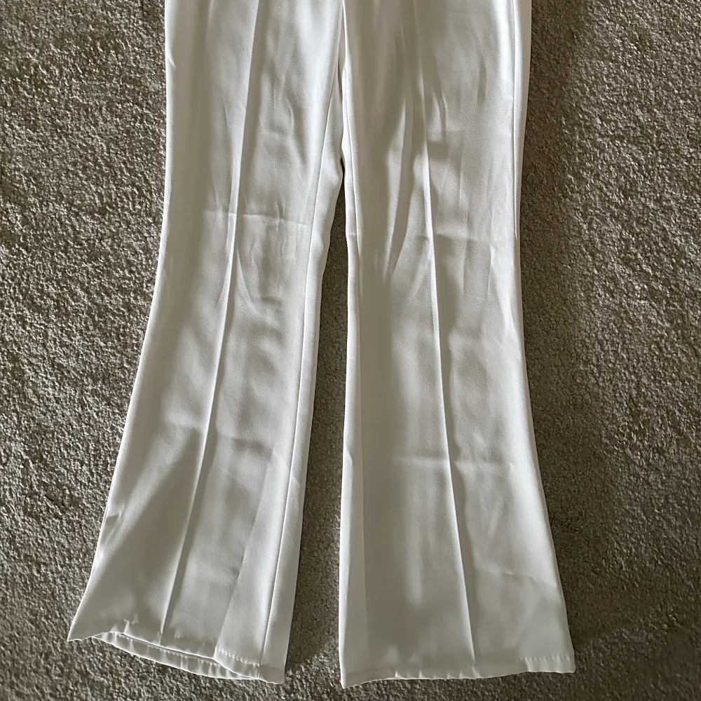 Vita kostymbyxor i bootcut modell.  Aldrig använda pga felköp. . Jeans & Byxor.
