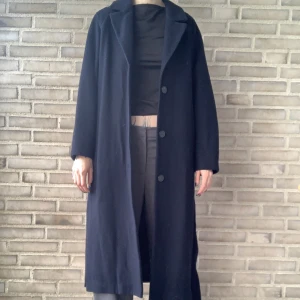 Kappa från Weekday - Mörkblå kappa i snygg längd. Jag är 172cm och den går strax nedanför mina knän. Perfekt till vintern! Se bilder för passform