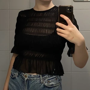 Topp - Svart gullig topp från Gina Tricot i tunt mesh material. Storlek M och stretchig. Felfri och aldrig använd. 