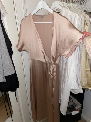 Champagne färgad omlottklänning - Från HM, använd 1 gång  Super fin men har aldrig tillfälle att använda, köpt för 500kr  Storlek S  Omlott så anpassningsbar.  