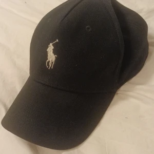 Ralph Lauren dadcap  - Svart Ralph Lauren dadcap, använd ca 3 gånger, passar till allt. QR koden är fortfarande fast.