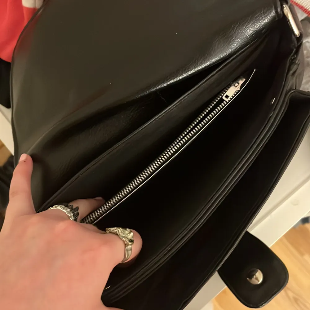 Cool svart väska med ett ej skysterbart band (men det går att ta av). Den har fyra fack. Köpt secondhand men jätte fint skick och aldrig använd från min sida🤘🏼VID INTRESSE HÖR AV DIG TRYCK INTE PÅ KÖP NU. Väskor.