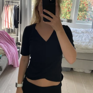 Svart omlott topp från No 365 i storlek S - Supersöt tshirt i omlott med längre ärmar från No 365. Superskönt material och bra kvalitet, inga som helst defekter. Nypris: 200 Storlek S men passar även XS
